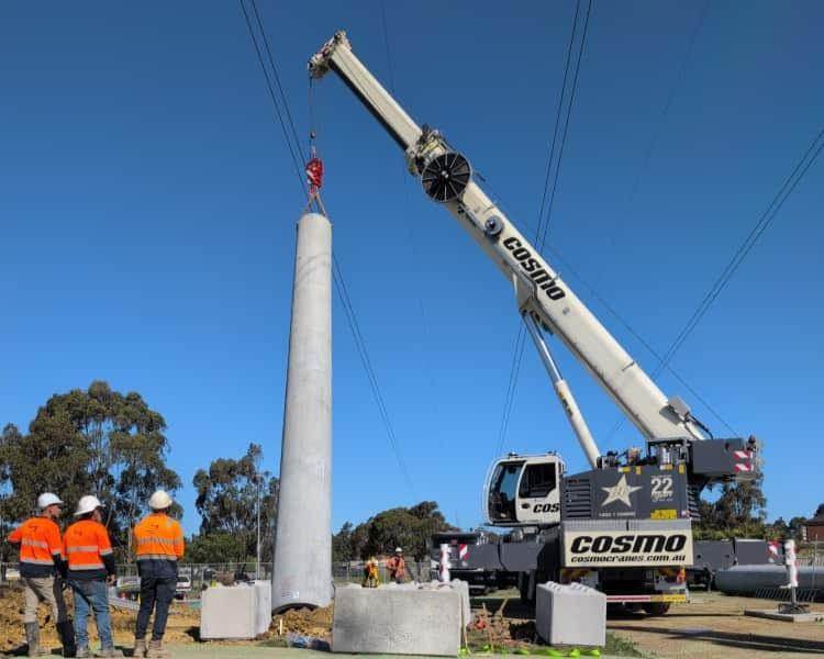 Crane lifting a pole into place